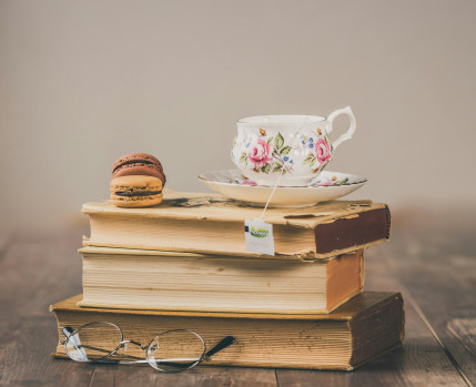 Livros empilhados com uma chávena de chá no topo