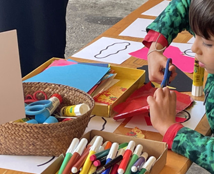 Criança a desenhar com canetas