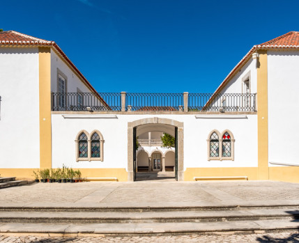 Fotografia da fachada principal da Casa da Cerca com os portões abertos