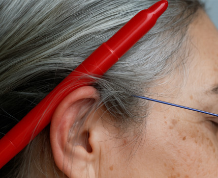 Foto de rosto com caneta vermelha atrás da orelha