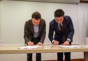 dois homens a assinar um documento