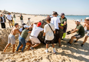 duas pessoas a limpar uma praia