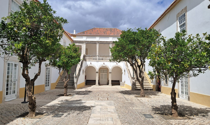 Foto do pátio de entrada da casa da Cerca, vendo-se as laranjeiras e as escadarias laterais