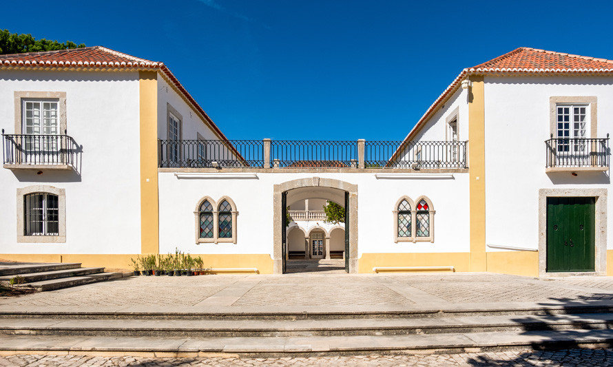 Fotografia da fachada principal da Casa da Cerca com os portões abertos