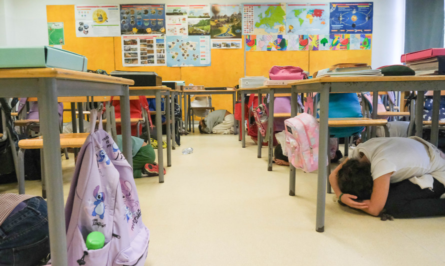 Crianças debaixo das secretarias num simulacro de sismo