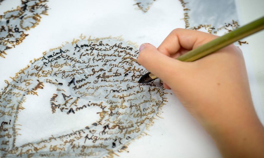 mão a desenhar com tinta de noz