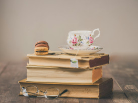 Livros empilhados com uma chávena de chá no topo