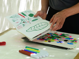 Bancada de trabalho com canetas coloridas e desenhos