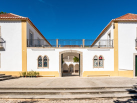Fotografia da fachada principal da Casa da Cerca com os portões abertos