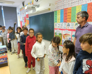 Alunos com professor a sair de uma sala de aula