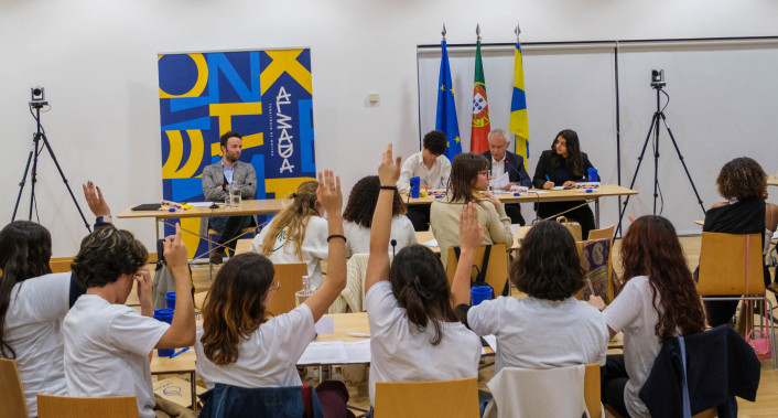 alunos a votar de braço no ar