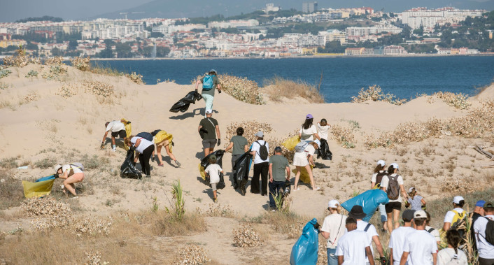 grupo de pessoas numa limpeza de praia