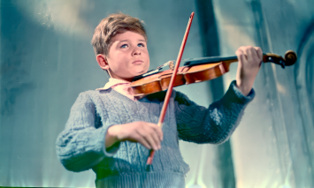Imagem do filme "O rolocompressor e o violinista" - criança a tocar violino